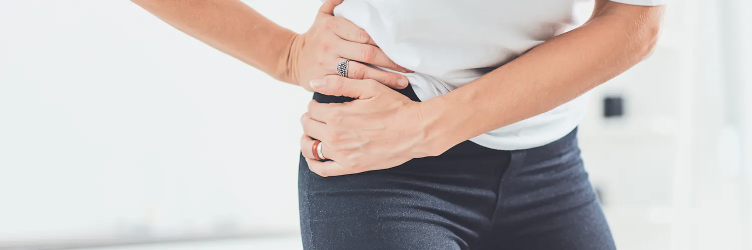 Frau greift sich an die schmerzende Hüfte