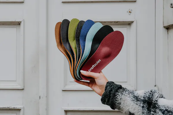 Frau hält Einlagen-Fächer in die Luft