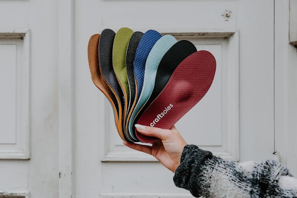 Frau hält Einlagen-Fächer in die Luft