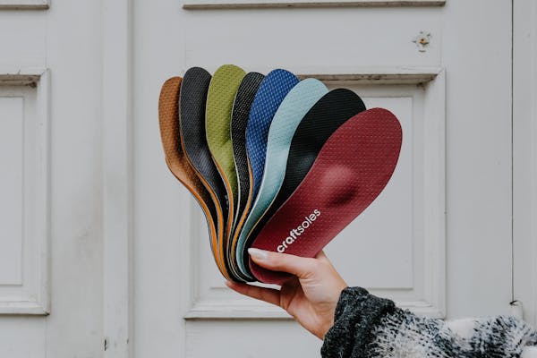 Frau hält Einlagen-Fächer in die Luft