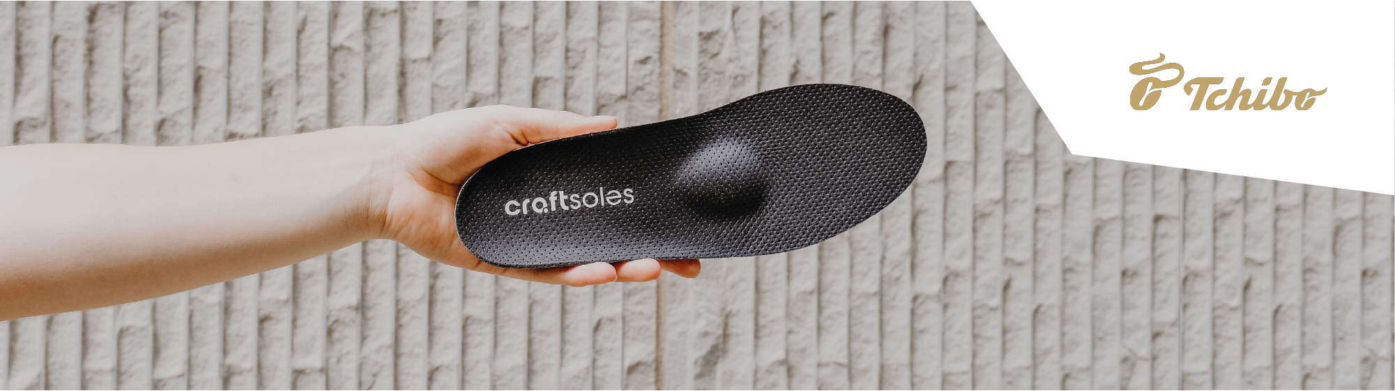 Frau hält Einlage in der Hand + Tchibo Logo in der Bildecke