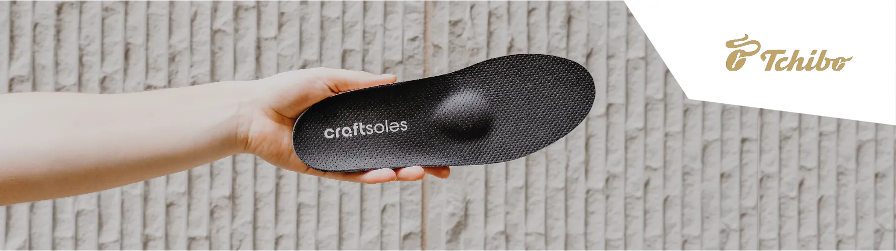 Frau hält Einlage in der Hand + Tchibo Logo in der Bildecke