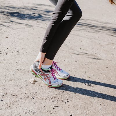 Frau greift sich an schmerzende Ferse