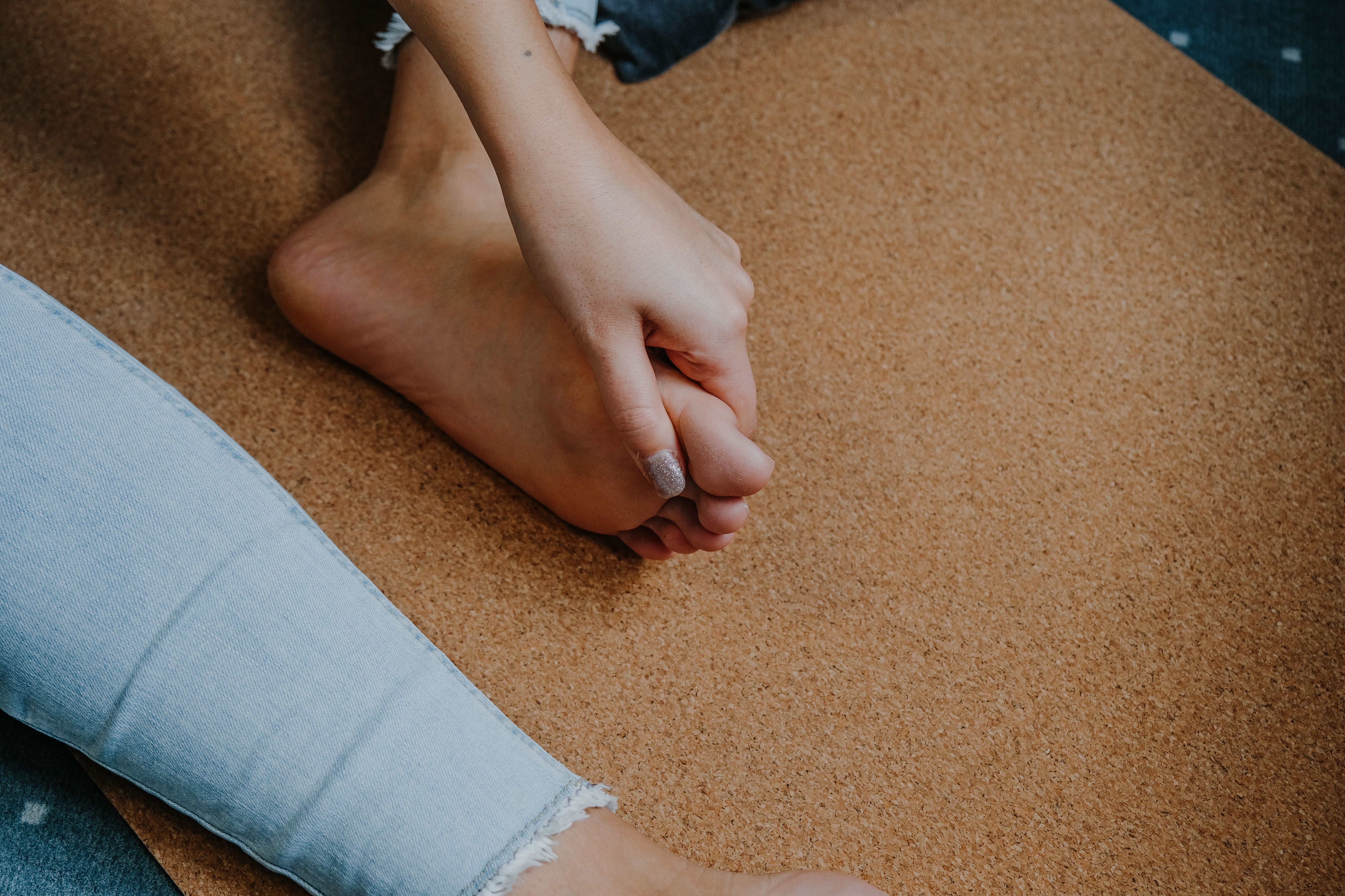 Frau greift sich an den schmerzenden Zeh