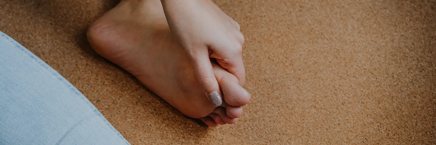 Frau greift sich an den schmerzenden Zeh