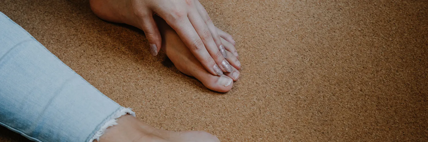 Frau greift sich an die schmerzenden Zehen
