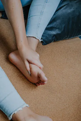 Frau greift sich an den schmerzenden Fuß