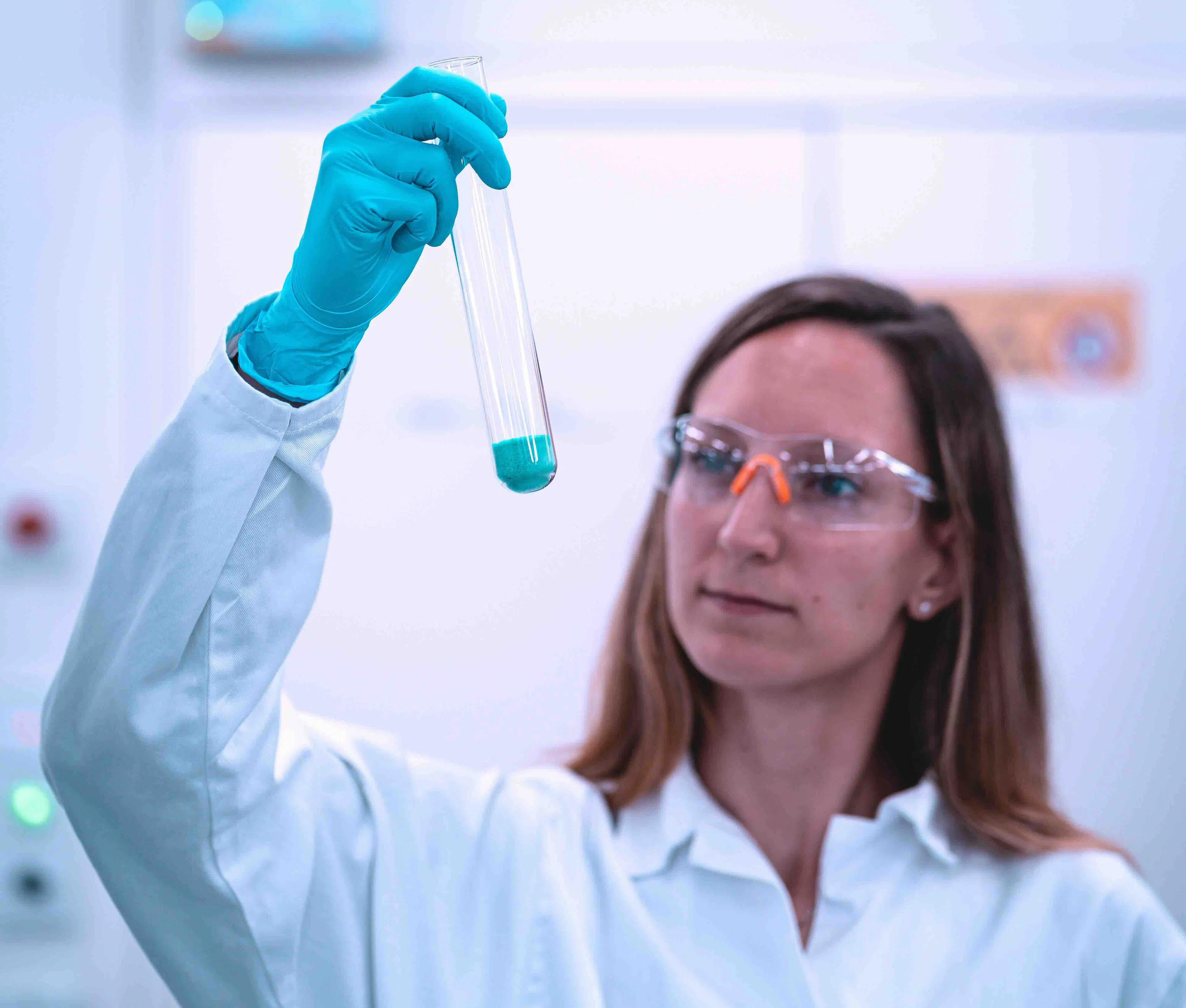 female chemist holding vial with powder