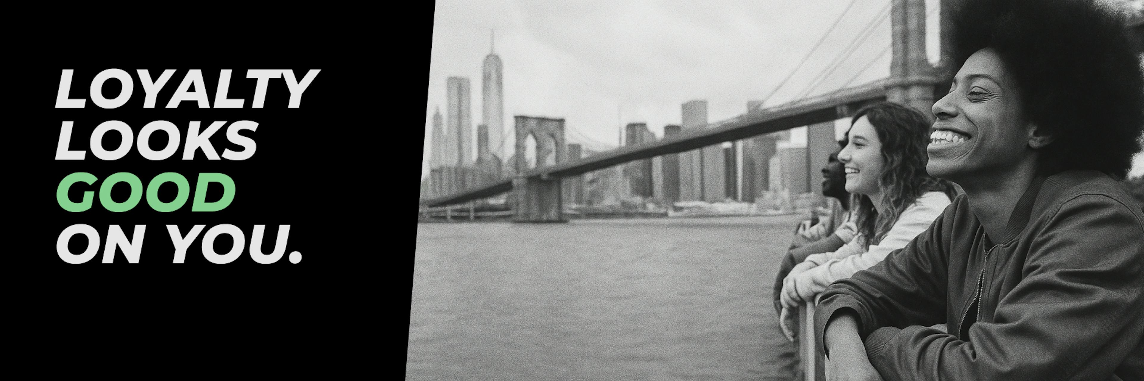 Black and white photo of three young people leaning on a railing by the waterfront, smiling and looking out toward the city skyline with the Brooklyn Bridge in the background. On the left, bold text reads: “LOYALTY LOOKS GOOD ON YOU,” with “GOOD” highlighted in green.