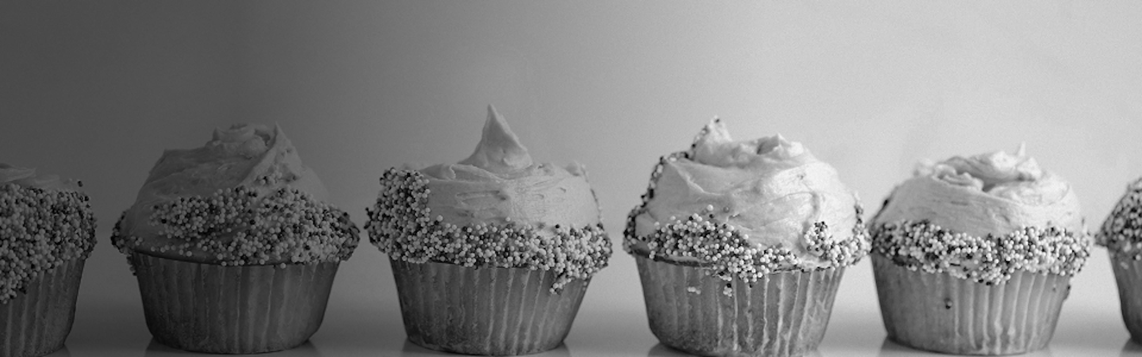 Frosted cupcakes lined up on a table, evoking sweet and creamy cannabis terpene categories like vanilla and cake strains