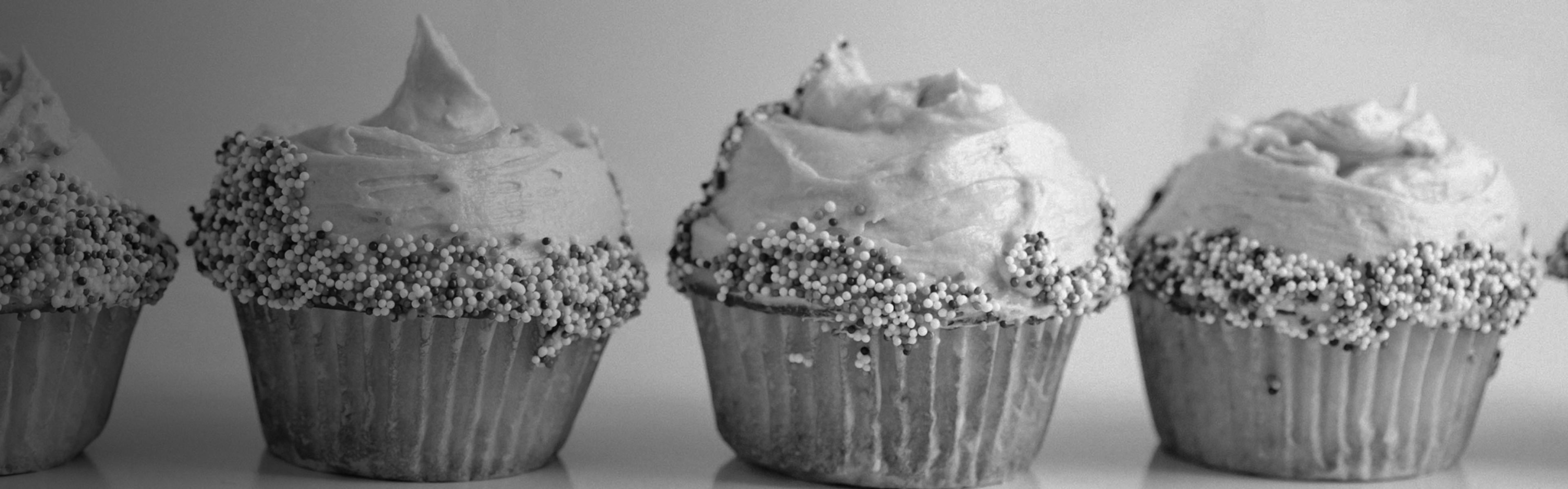 Frosted cupcakes lined up on a table, evoking sweet and creamy cannabis terpene categories like vanilla and cake strains