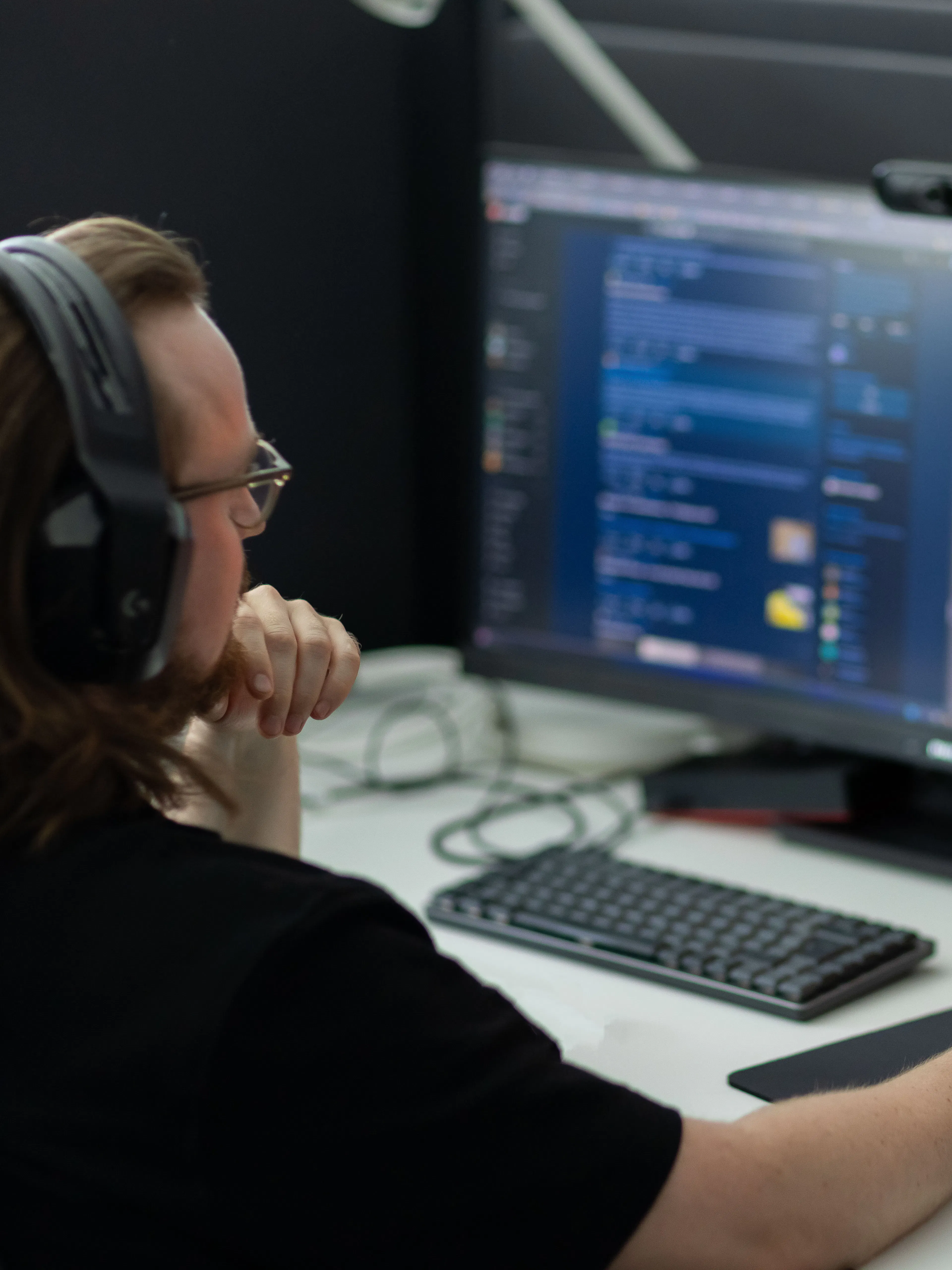 Man som sitter med headset framför ett datorskärm.