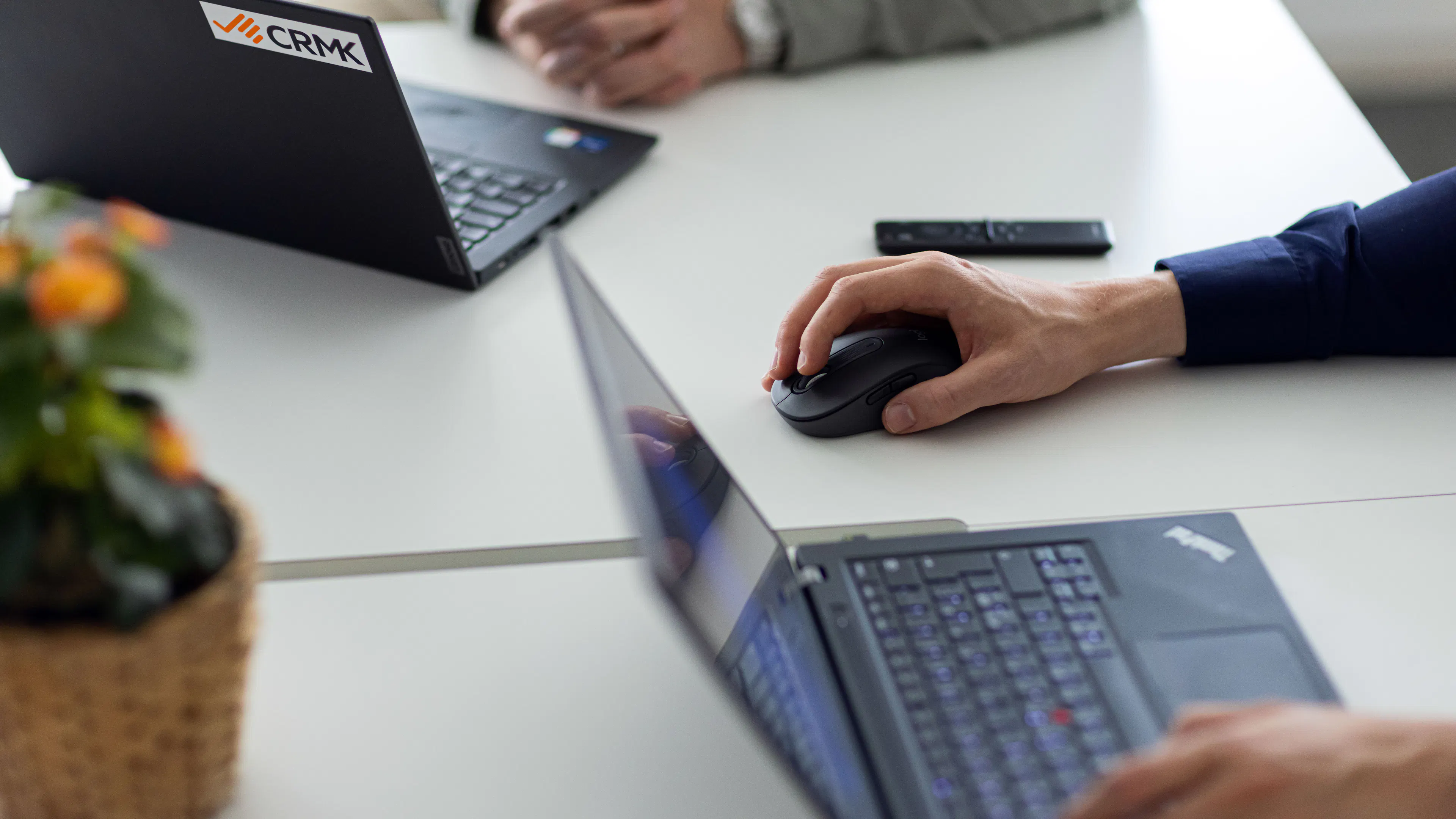 Två laptops på ett bord. Där man endast ser människornas händer.