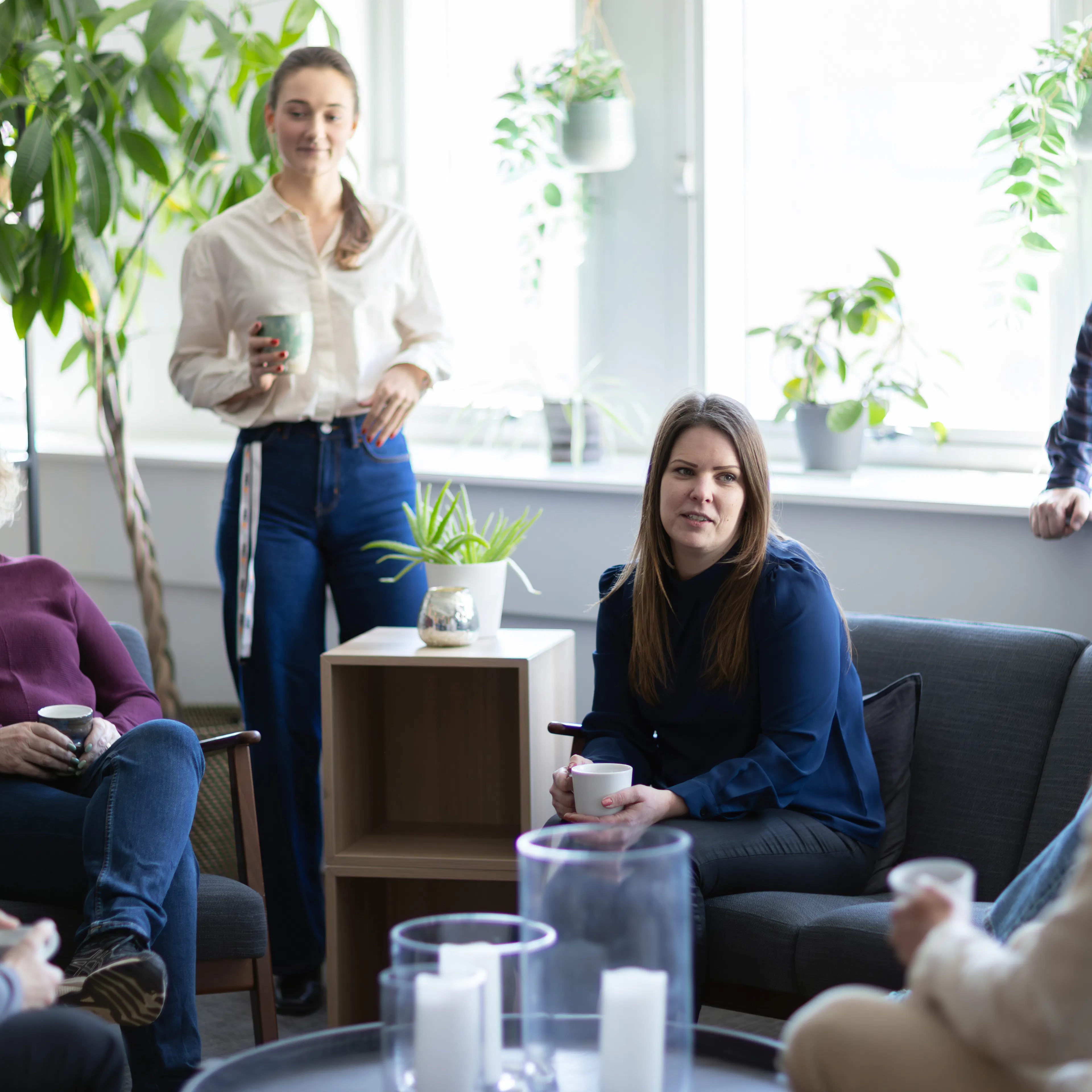 Grupp som sitter och fikar i ett kontorslandskap.