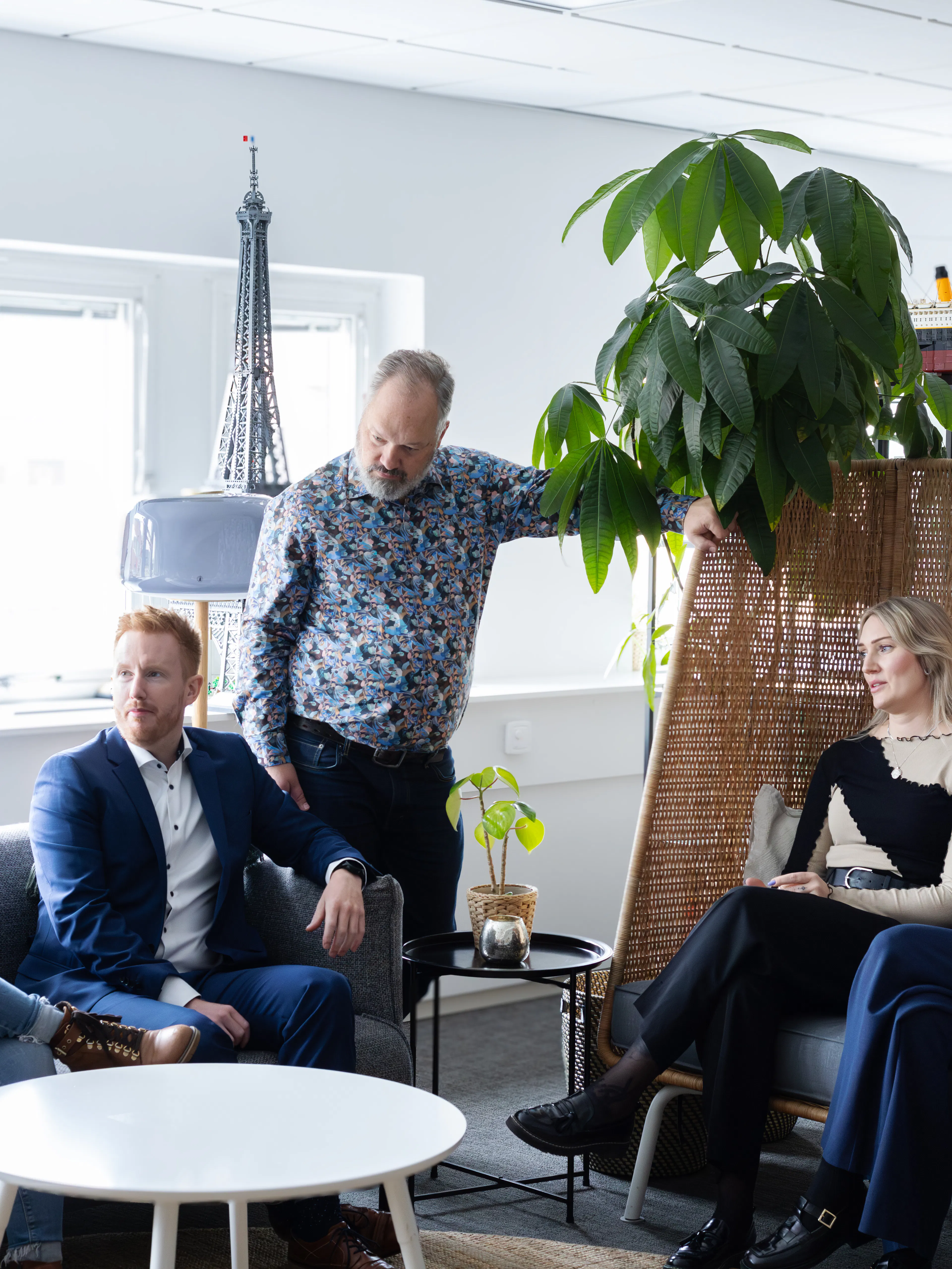 Sex personer som sitter i en soffgrupp och pratar med varandra.