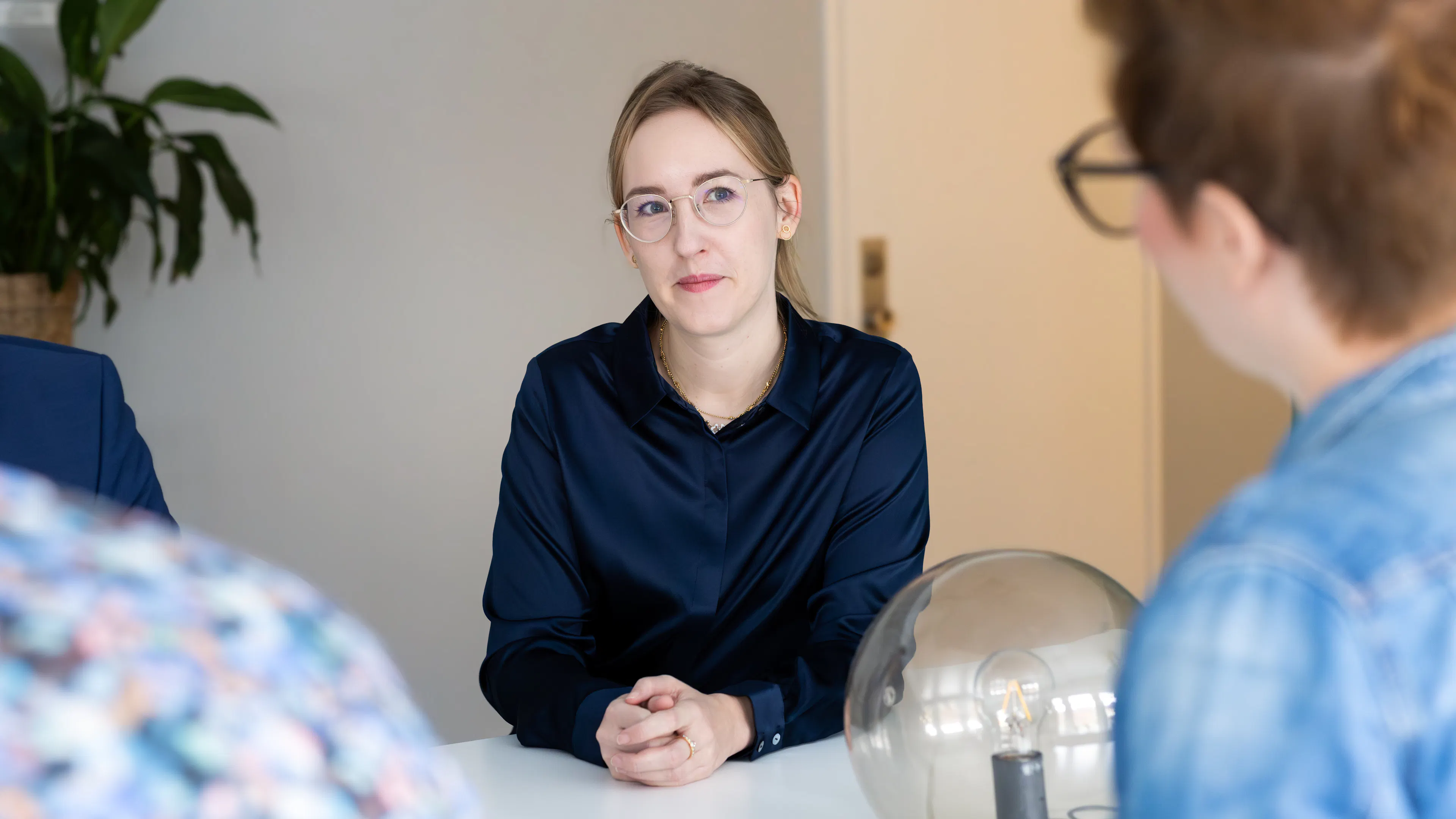 Kvinna i blå skjorta och glasögon