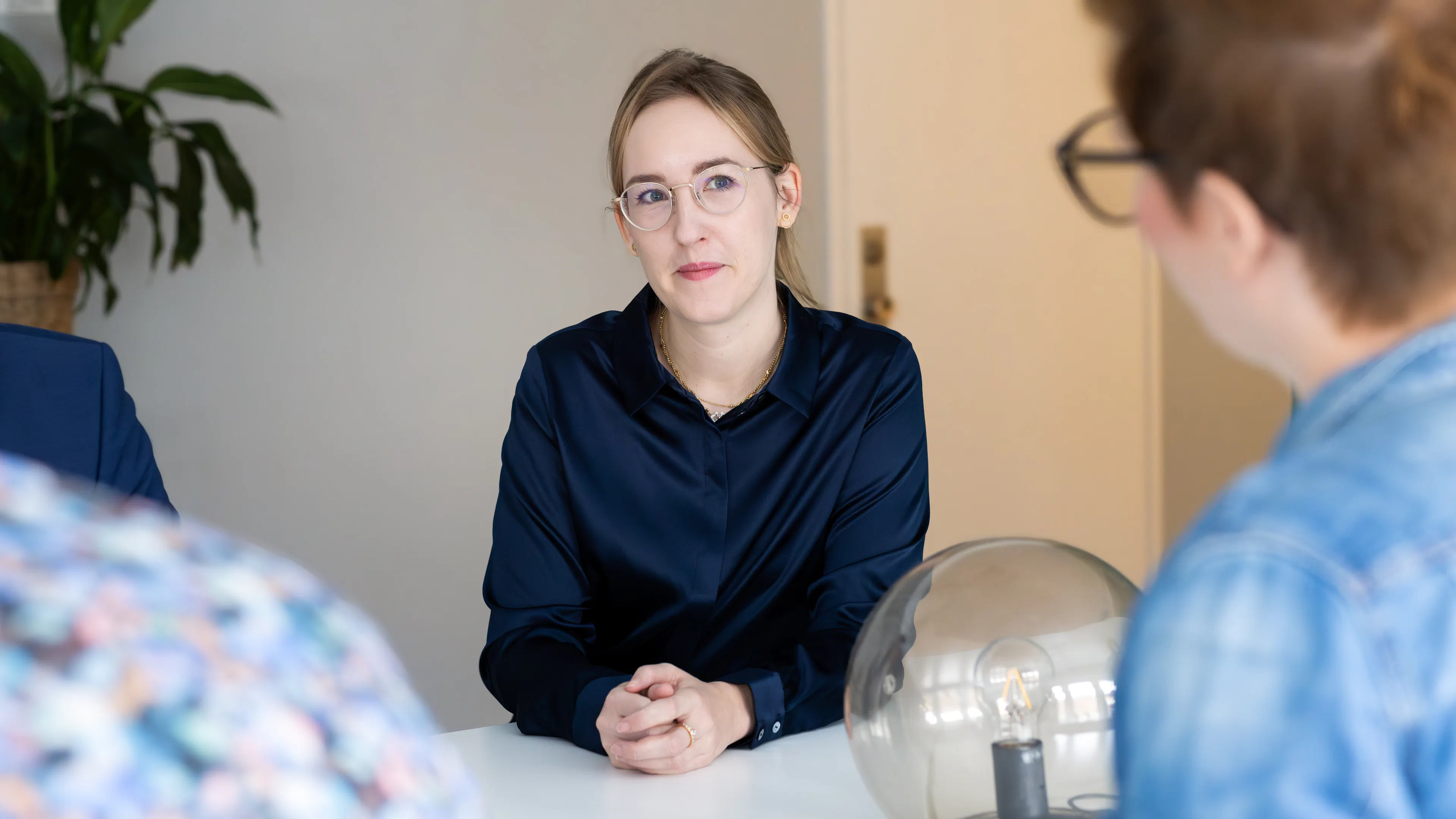 Frau in blauer Bluse und mit Brille