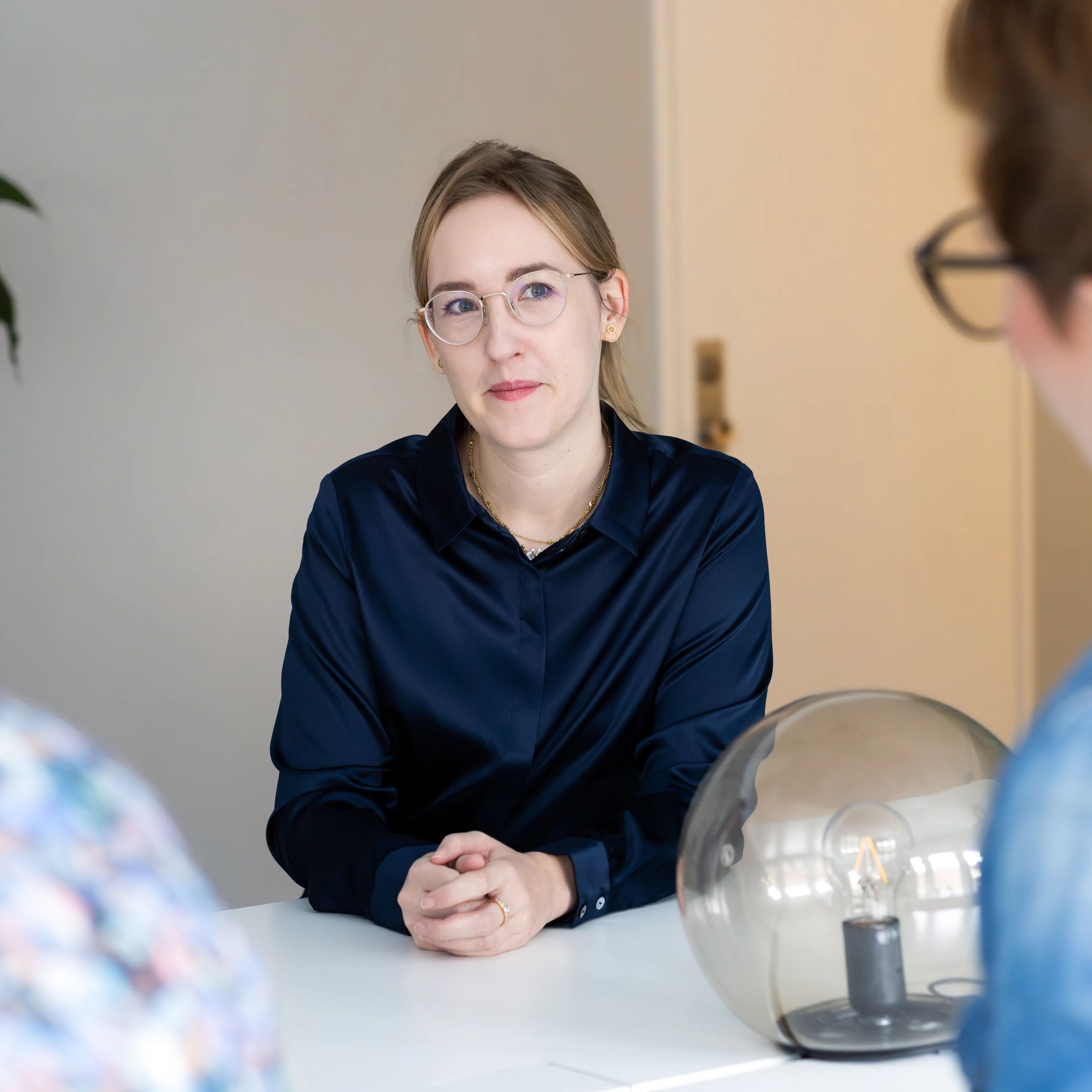 Kvinna i blå skjorta och glasögon