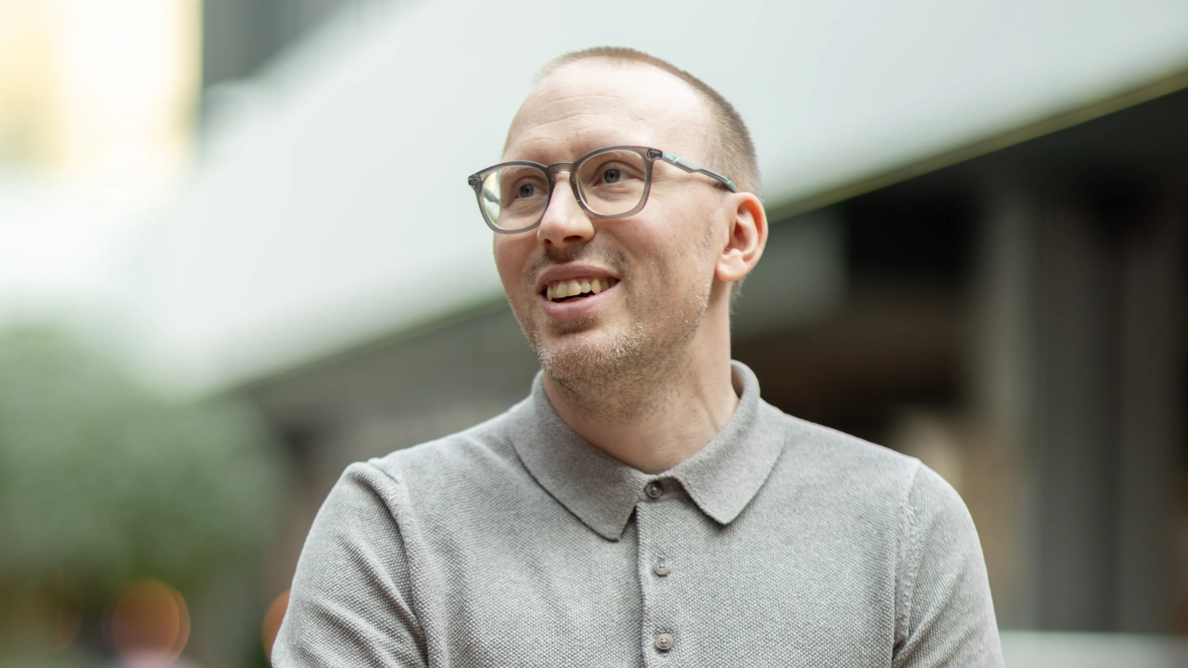 Mann in grauem Poloshirt, mit kurzem Haar und Brille.