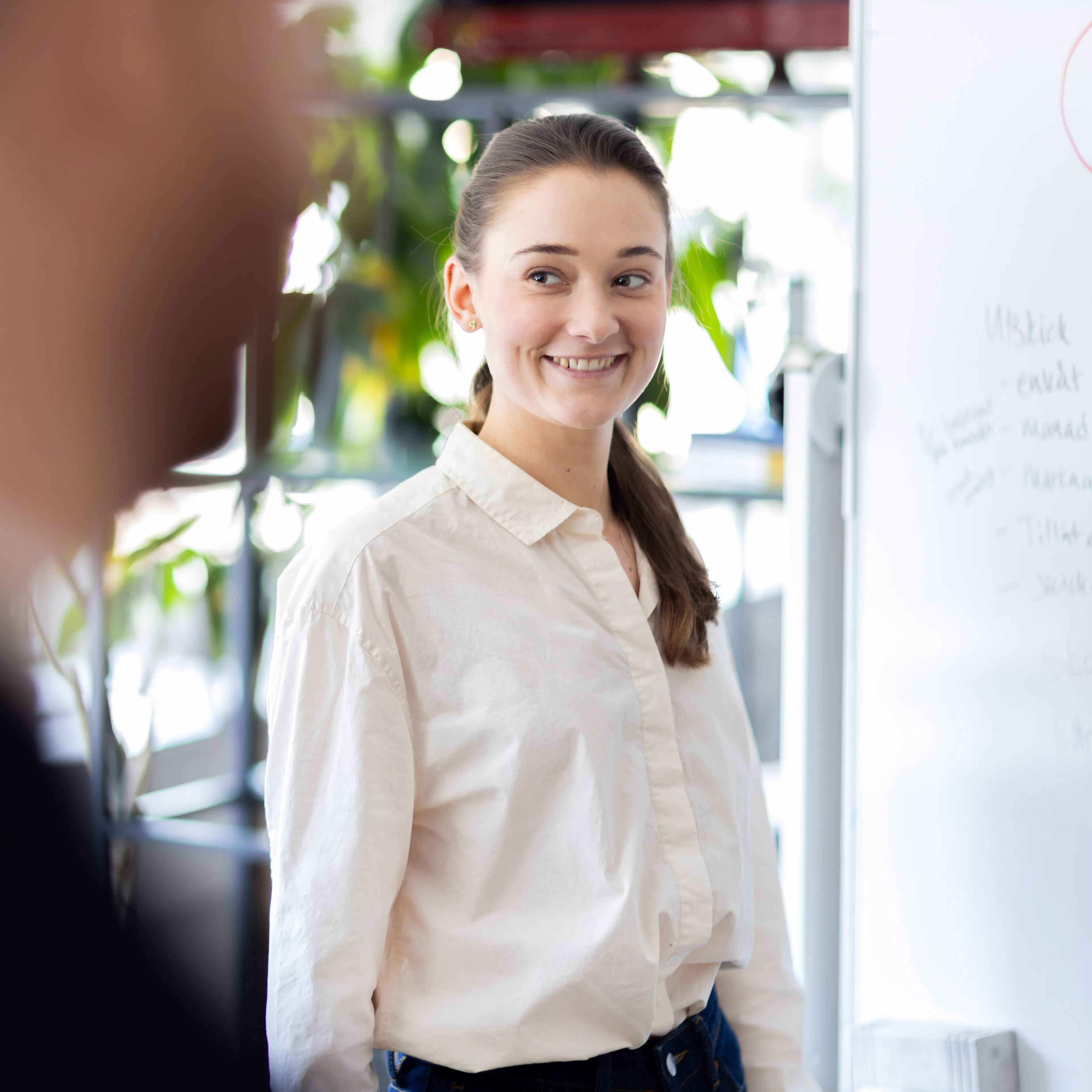 Eine Frau in einer weißen Bluse, die lächelt