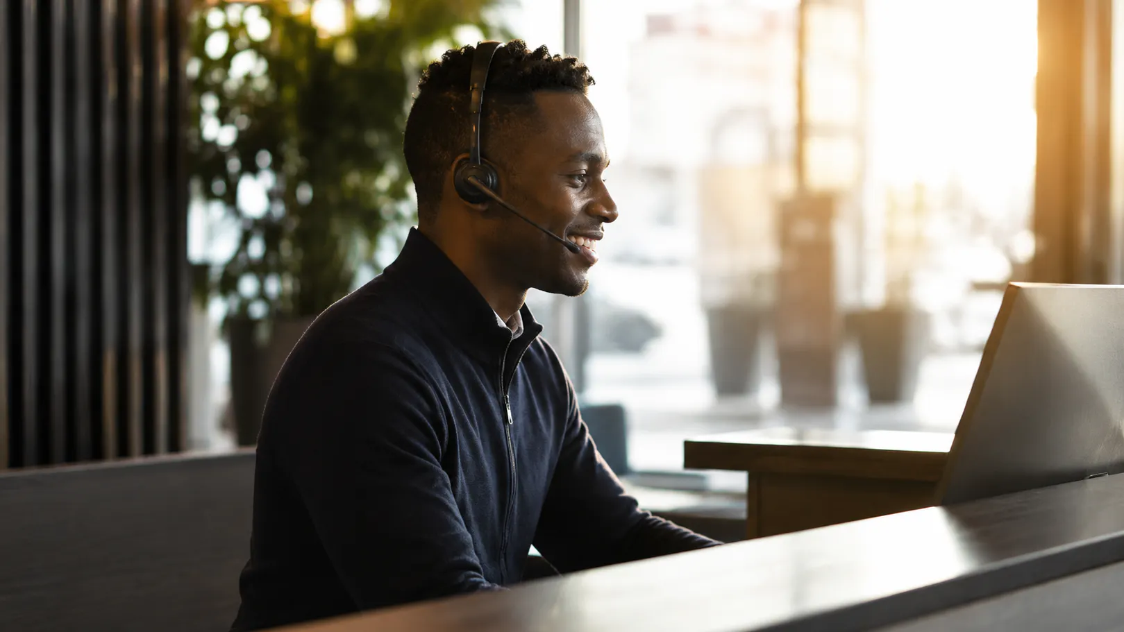 Man som sitter med headset framför en skärm