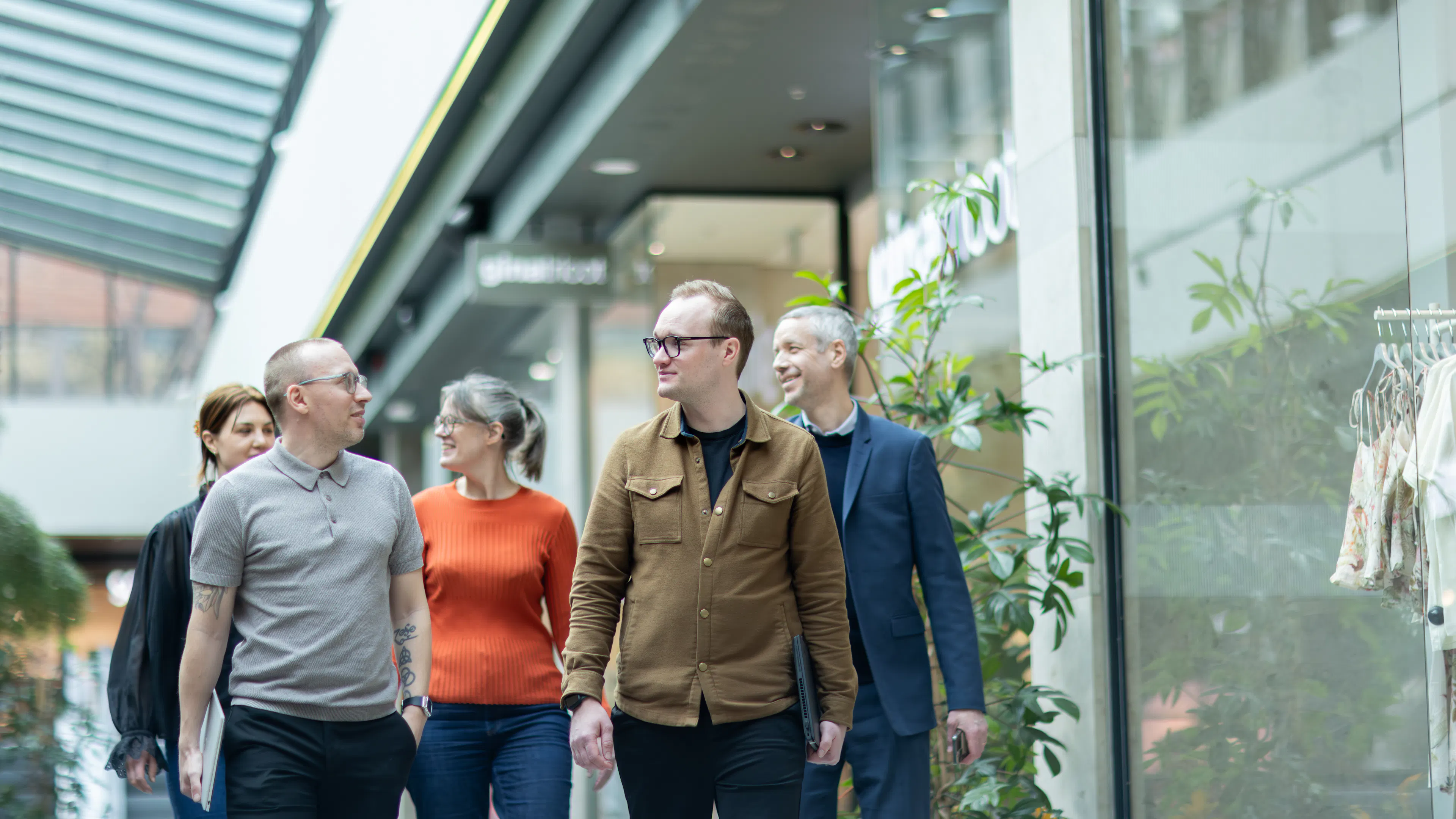Fem personer som får i en galleria
