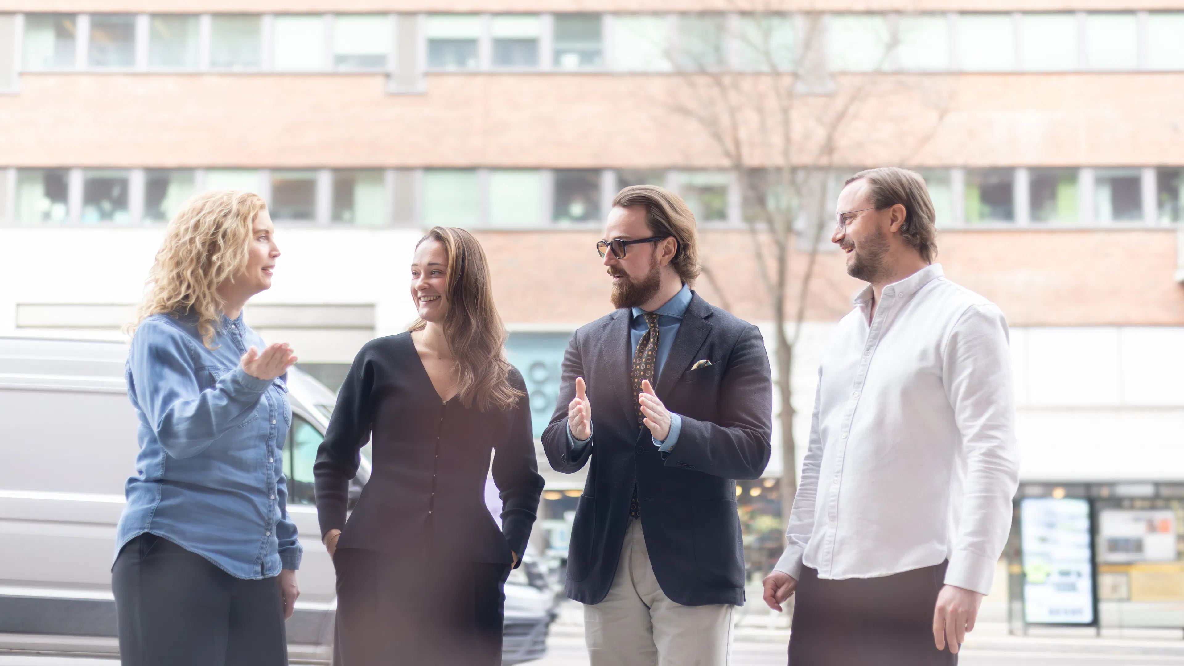 Fyra personer som står och diskuterar på gatan.