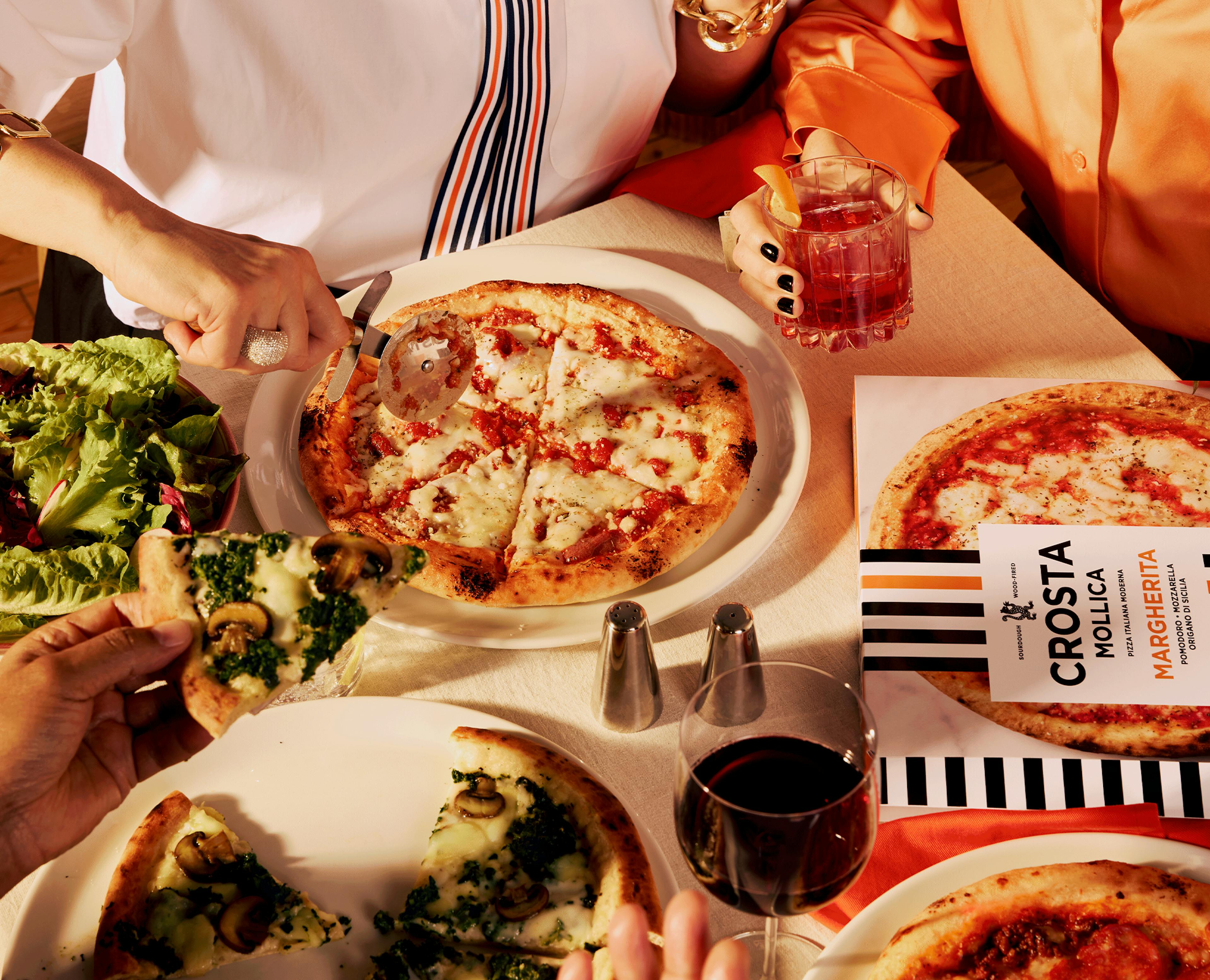 Crosta Mollica's competition: Win a Weekend in Italy for two. Image featuring Margherita Pizza and people around the table.