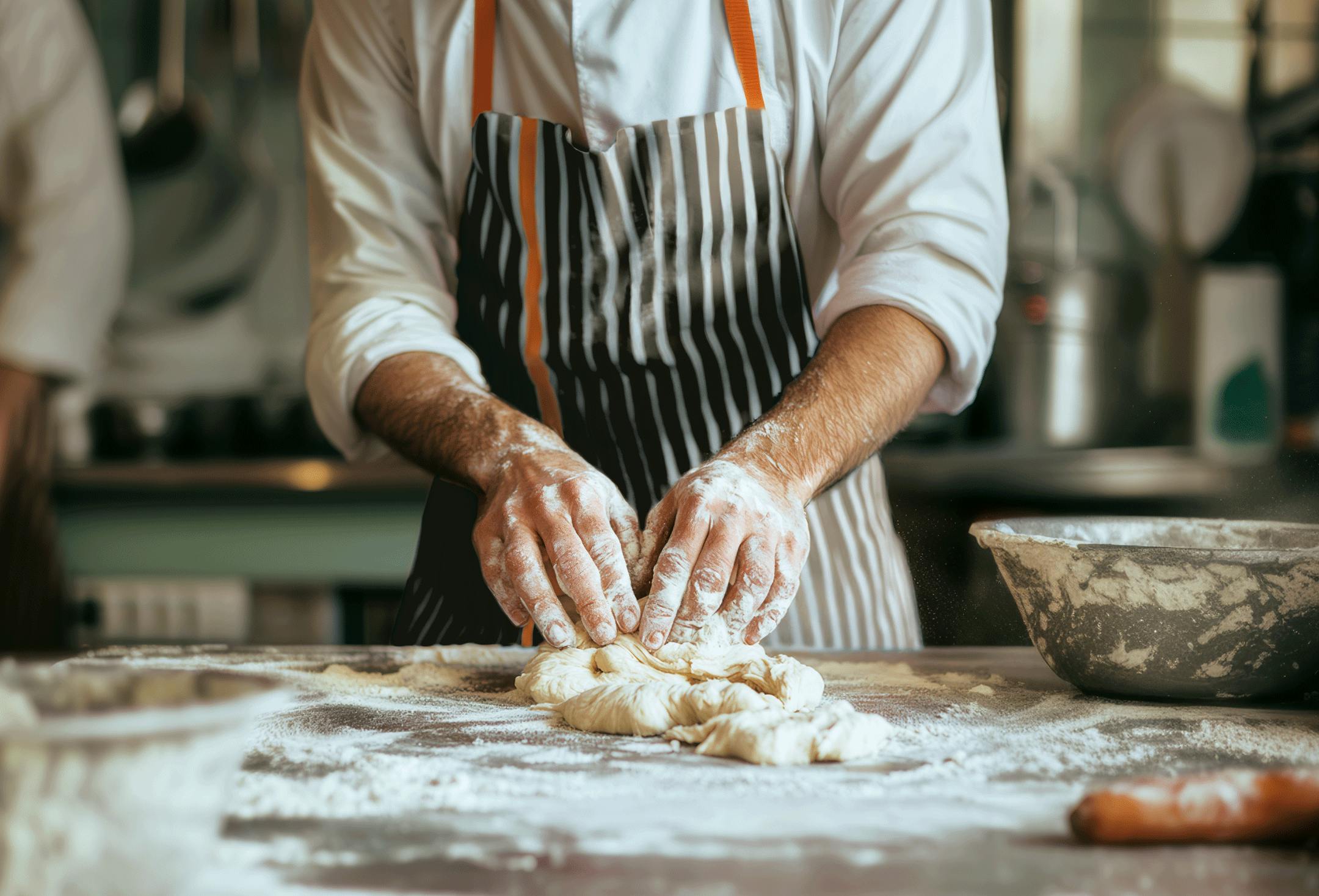Person working on a dough with Crosta Mollica’s striped apron.