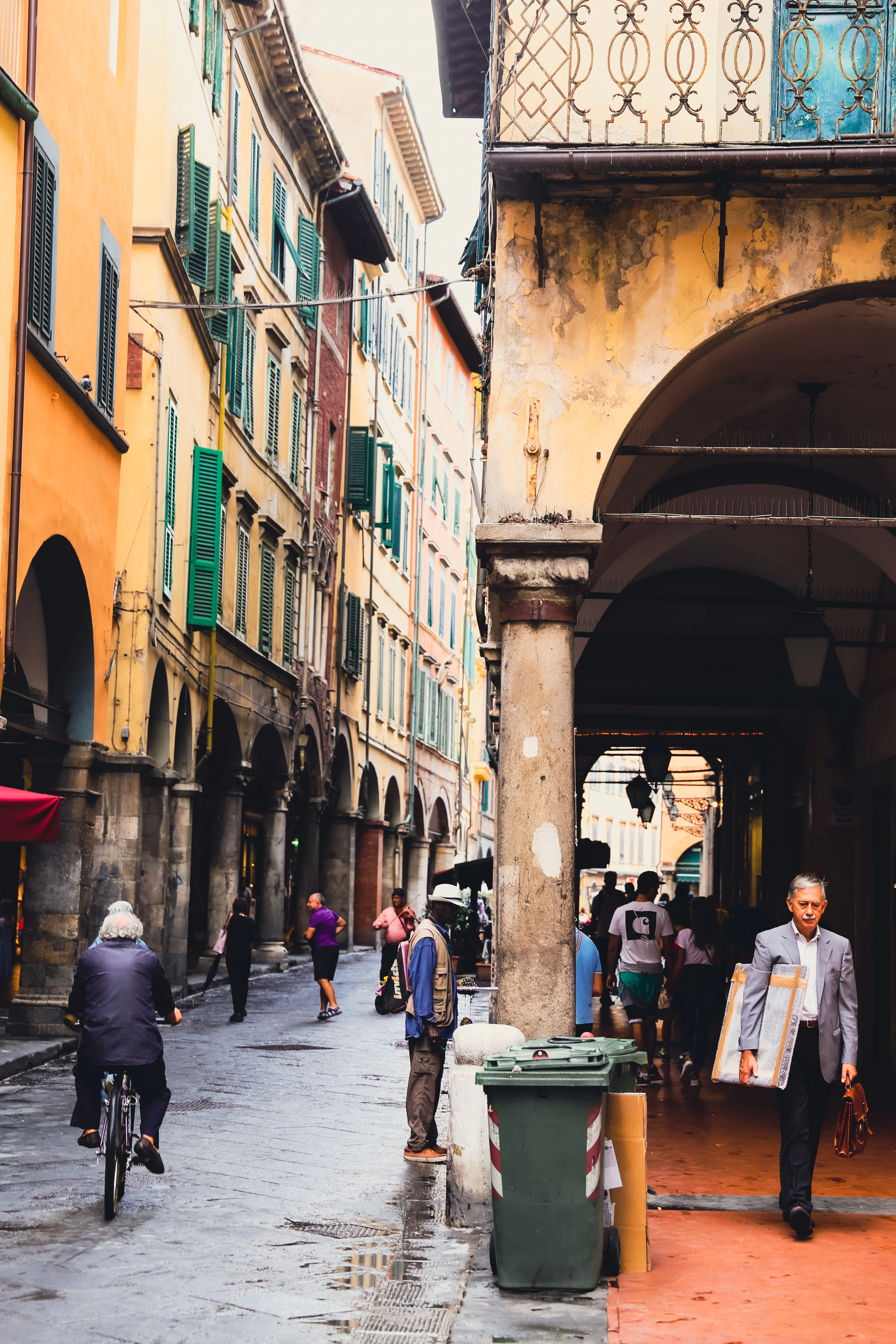 An Italian street with tall buildings on it.