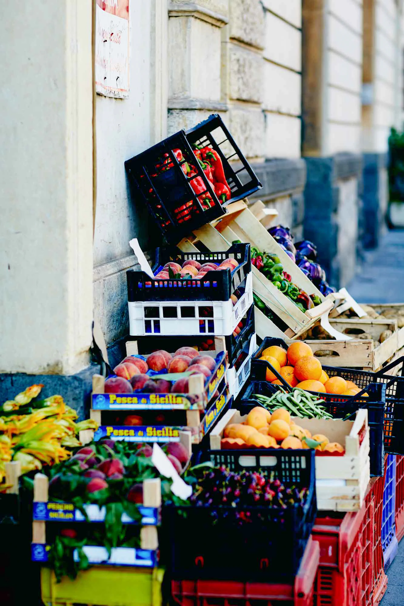 Crates of fruit and vegetables stacked against a wall
