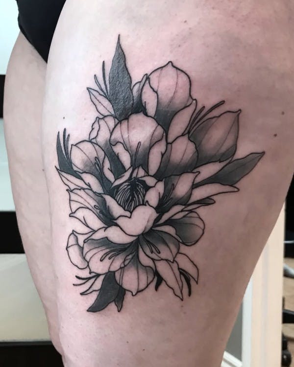 Tattoo of a flower on a thigh.