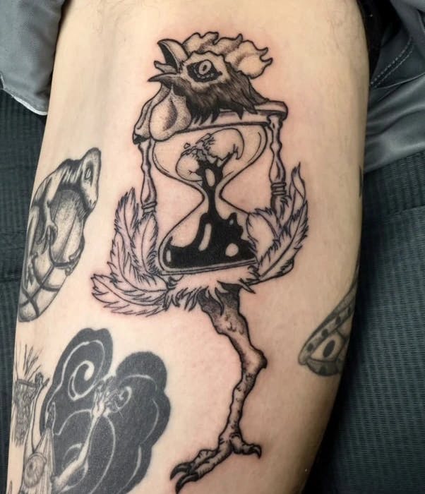 Tattoo of a rooster with an hourglass for a body and a cracked egg leaking inside the hourglass.