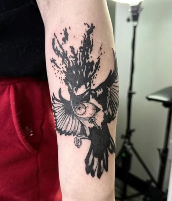 Tattoo of a bird with its head blown off and an eyeball on its chest.