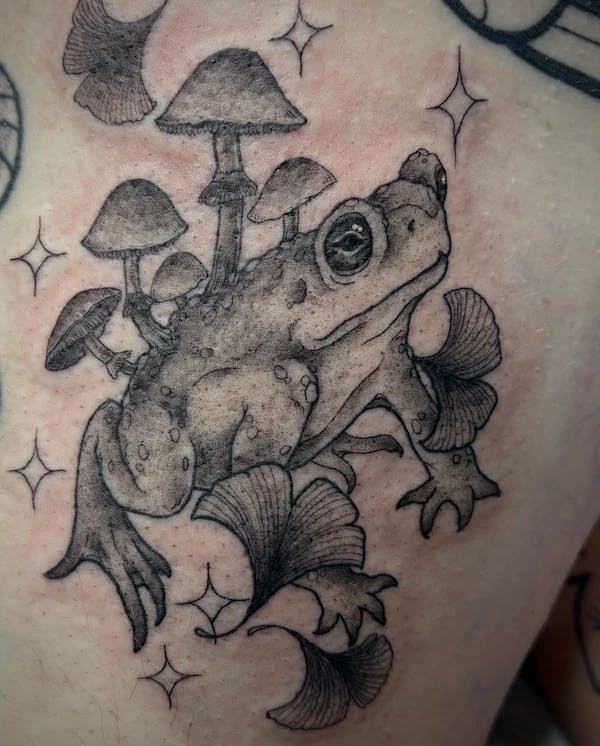 Tattoo of a magical frog with mushrooms growing on its back.