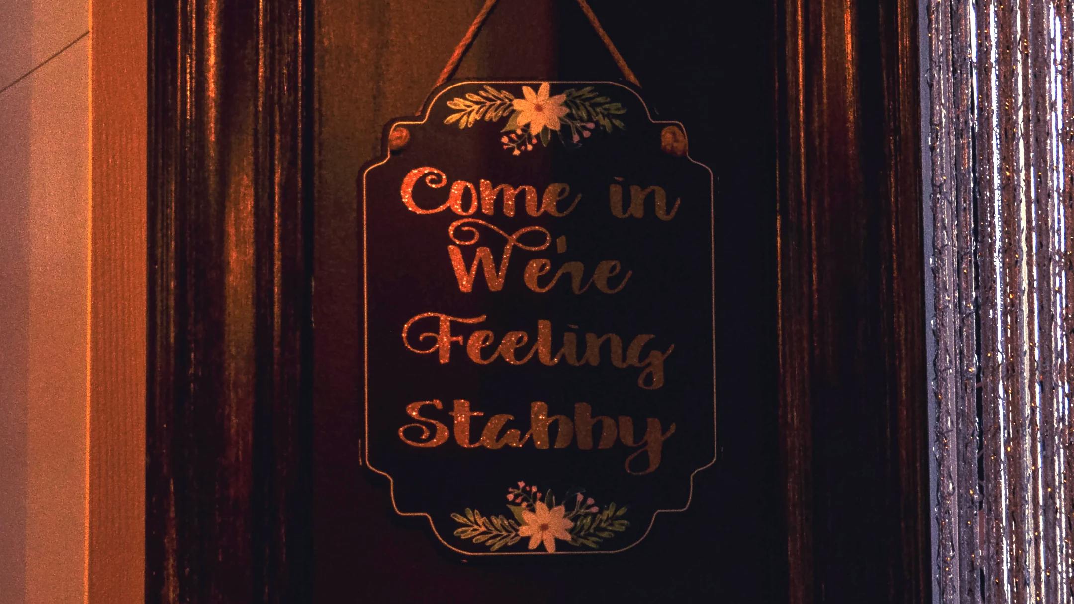 Crown & Serpent's entry way with a sign that says," Come in, we're feeling stabby."