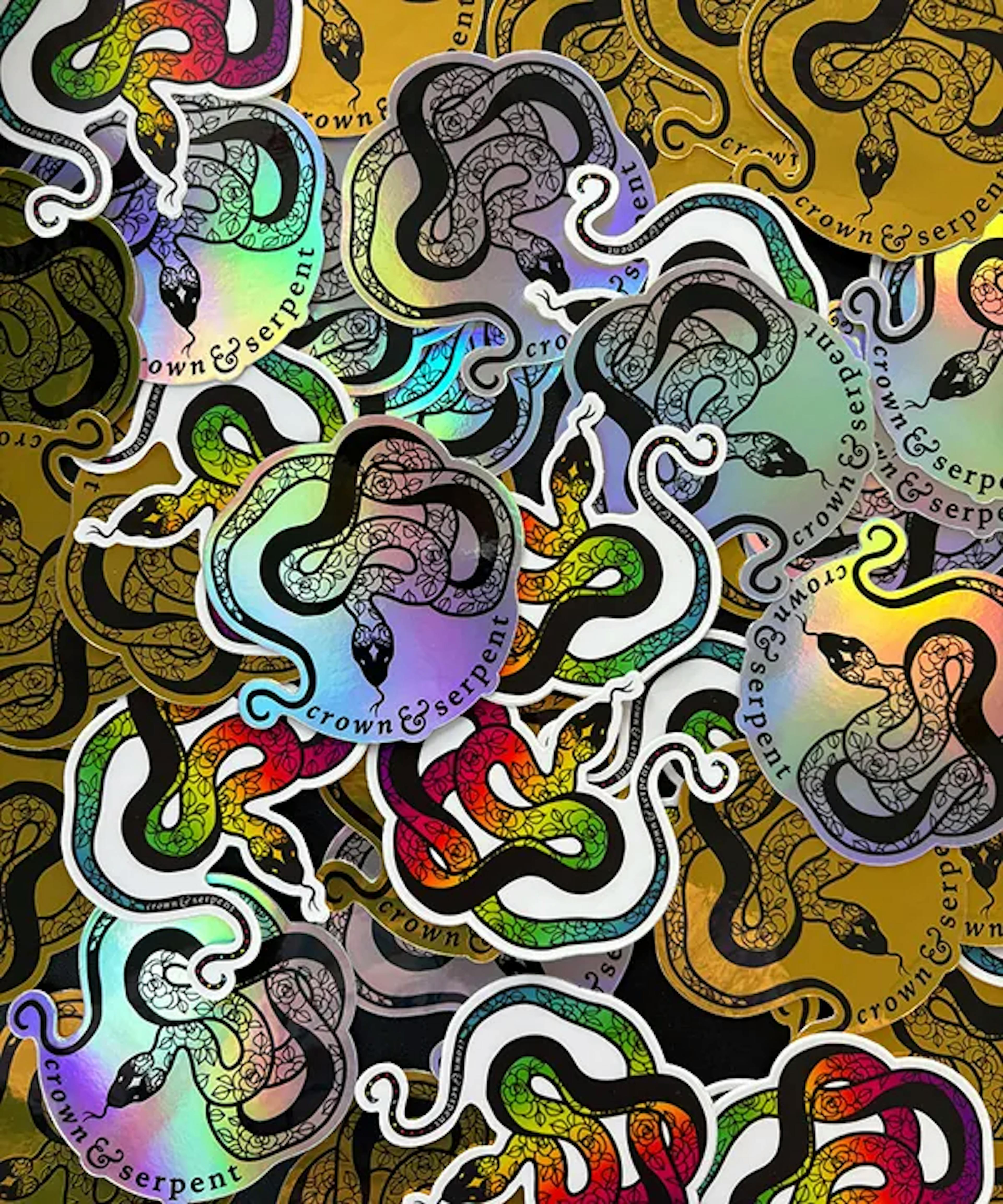 A holographic collection of Crown & Serpent's logo stickers in various colors.