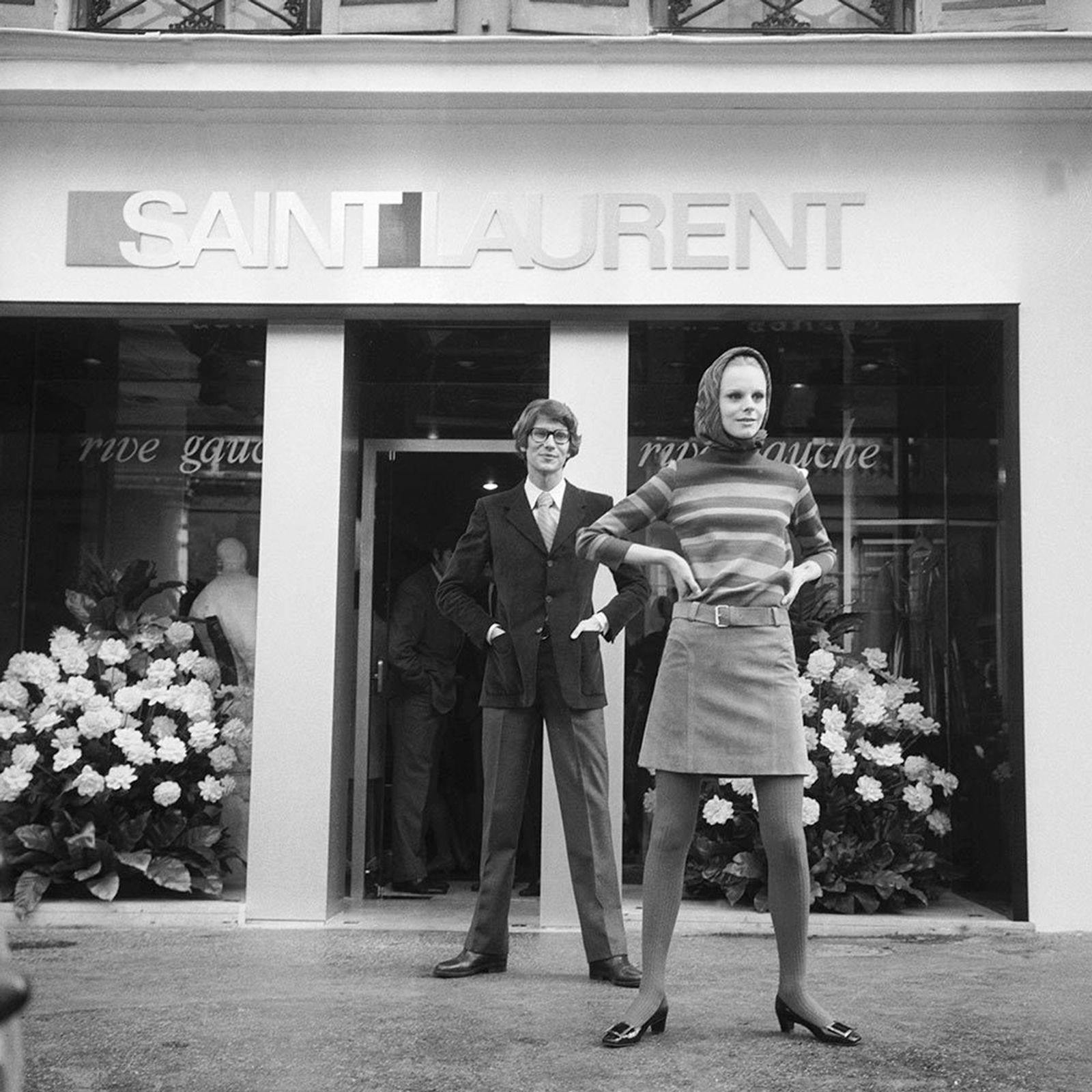Yves Saint Laurent and a model in front of his first Parisian boutique.