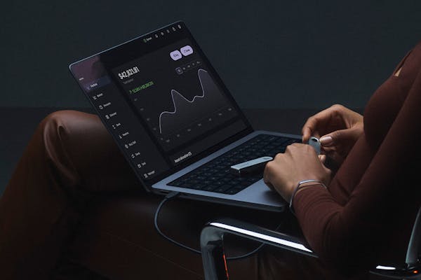 Ledger wallet laying on a Macbook that displays the Ledger Live app