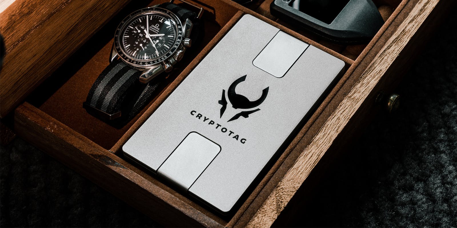 Cryptotag Zeus next to luxury watch