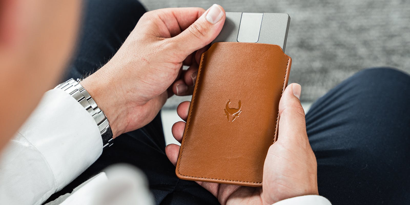 Man holding Cryptotag Zeus and Cryptotag Stack Sack Leather Case Metal Backup Seed Phrase Crypto Wallet