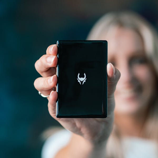 Woman Holding Cryptotag Loki BIP39 and SLIP39 recovery seed backup for Crypto wallets