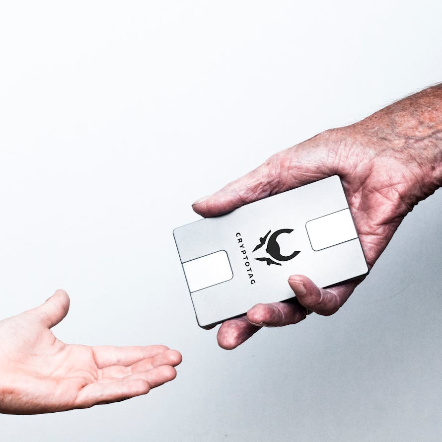 CRYPTOTAG Legacy old man handing over cryptotag to son two hands