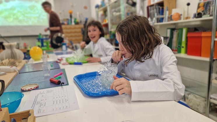 Les chercheurs et chercheuses en herbe du Kinderlab explorent les surfaces créées par la fusion d'eau et de savon.
