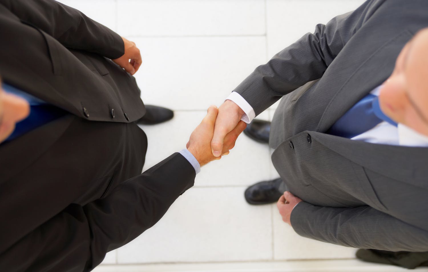 Two men in business suits shaking hands