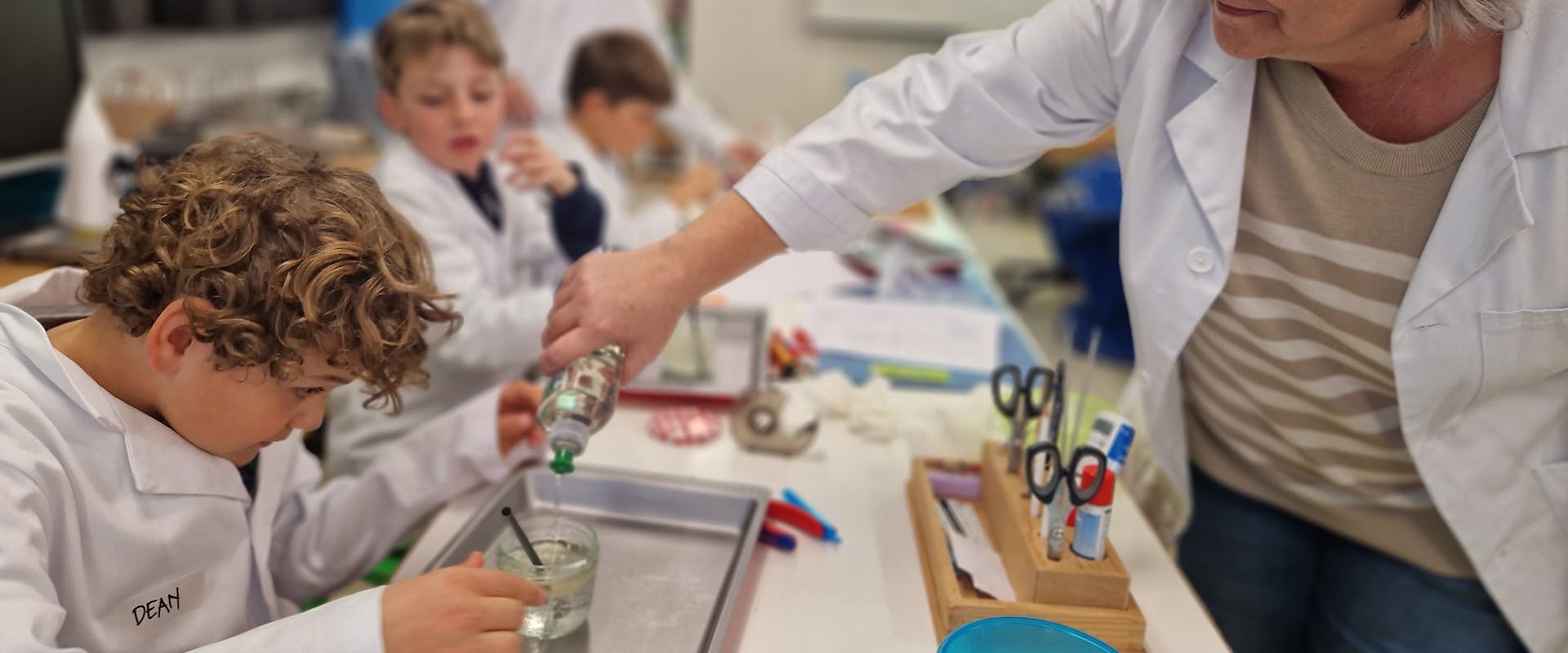 Reufa Junuzovic, experte au CSEM, guide les jeunes du Kinderlab dans leur expérience sur la surface des bulles de savons.