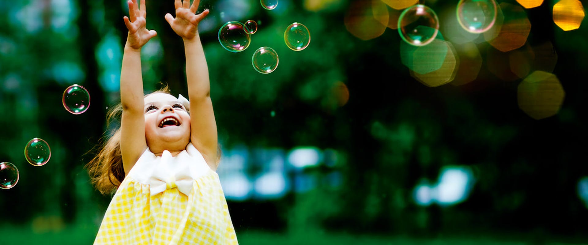 Little girl playing with soap bubbles