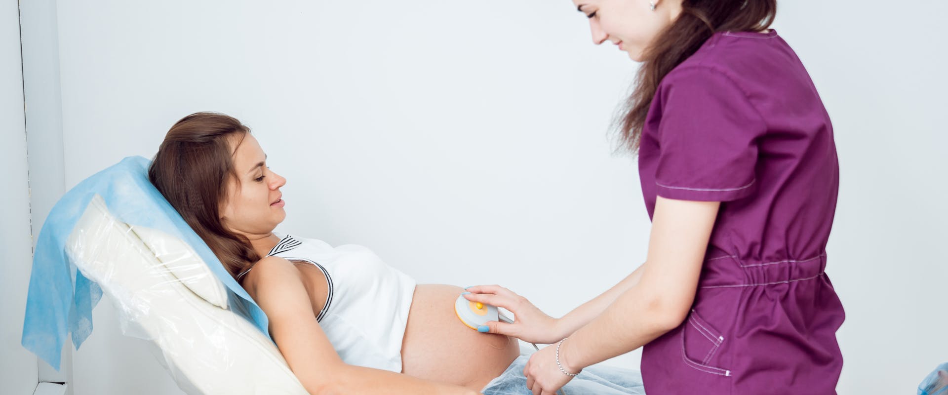 Femme enceinte bénéficiant d'un contrôle électrocardiographique pour son bébé dans le cadre d'un monitoring fœtal.