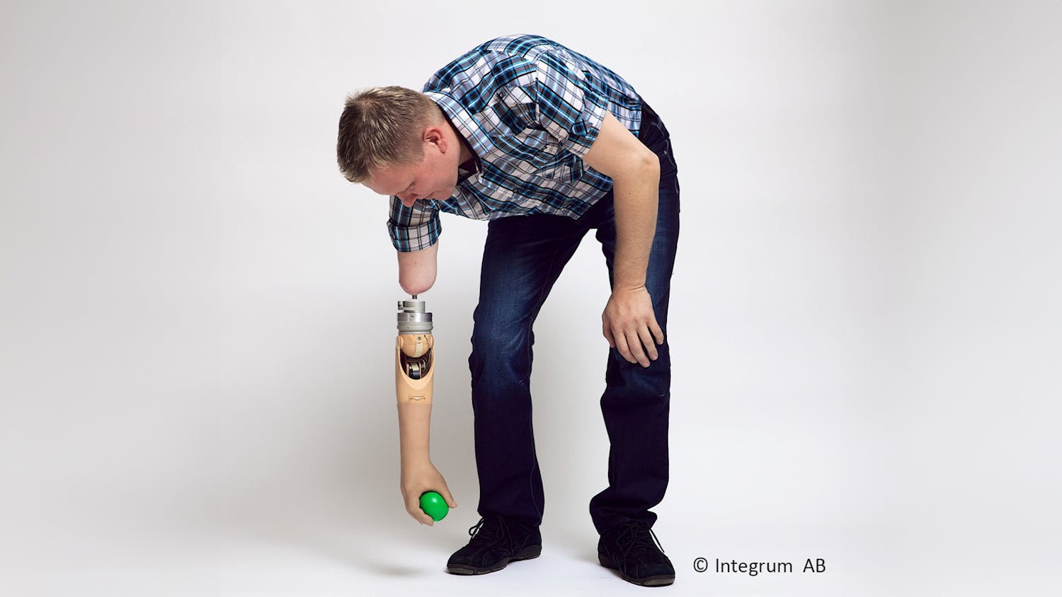A patient with a neuroprosthesis picks up a rubber ball from the floor.