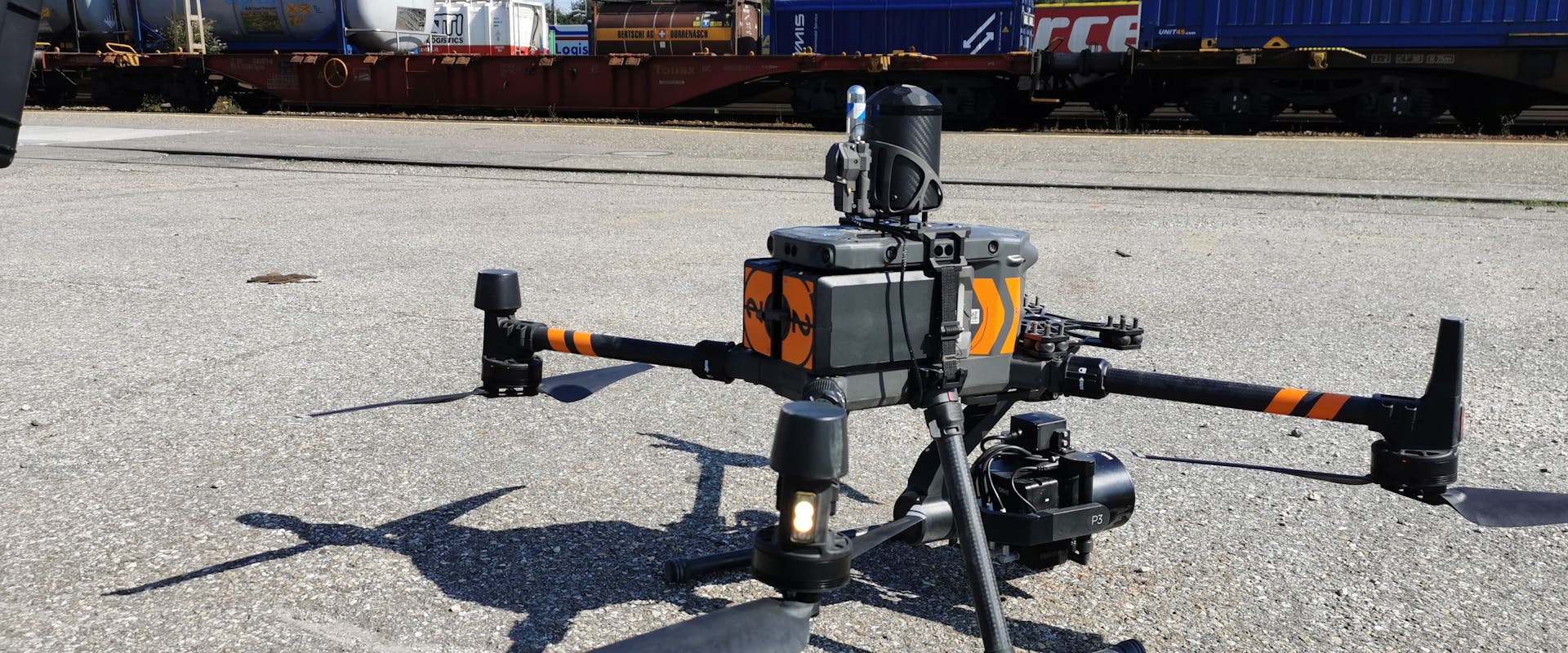 Eine Drone steht auf dem Boden vor Bahngleisen